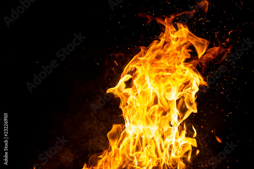 Burning woods with firesparks, flame and smoke. Strange weird odd elemental fiery figures on black background. Coal and ash. Abstract shapes at night. Bonfire outdoor on nature. Strenght of element.