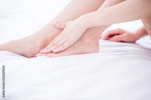 Woman applying cream onto foot