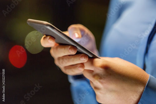 business, technology and people concept - close up of businesswoman hands with smartphone