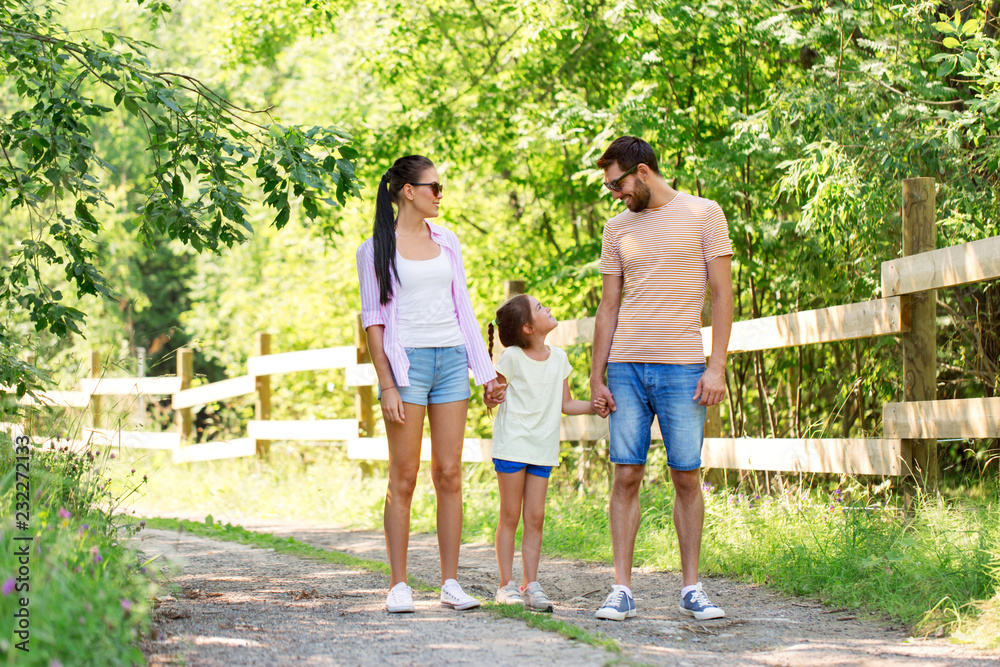 family, leisure and people concept - happy mother, father and little daughter walking in summer park family, leisure and people concept - happy mother, father and little daughter walking in summer park