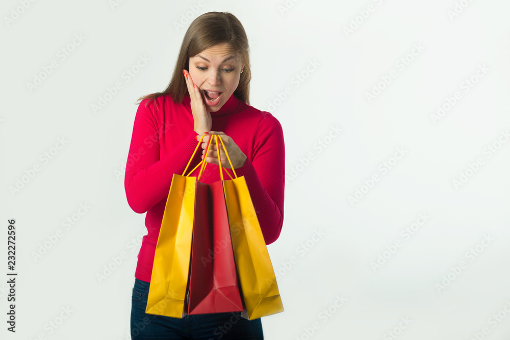 beautiful young girl holding a purchase in soft bags on a white background beautiful young girl holding a purchase in soft bags on a white background