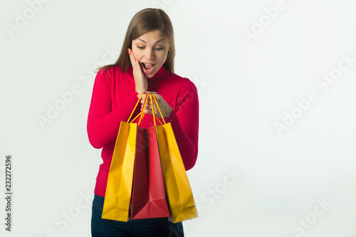 beautiful young girl holding a purchase in soft bags on a white background