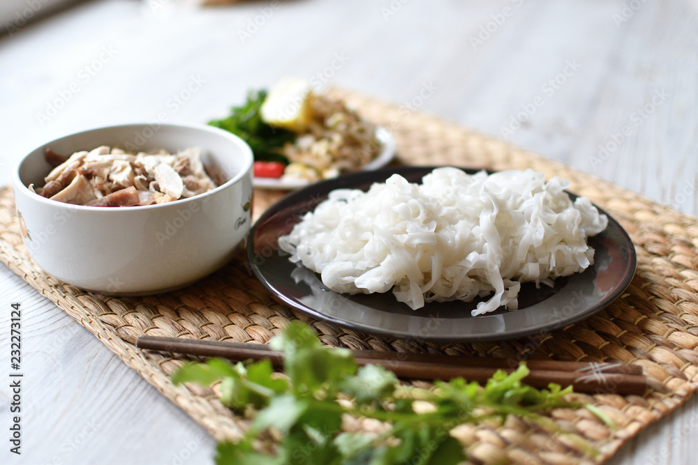 Fresh pho noodles on a plate. Wide flat rice noodles. Side view.