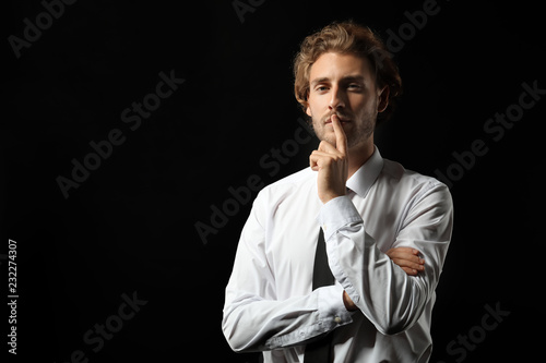 Portrait of young businessman on black background