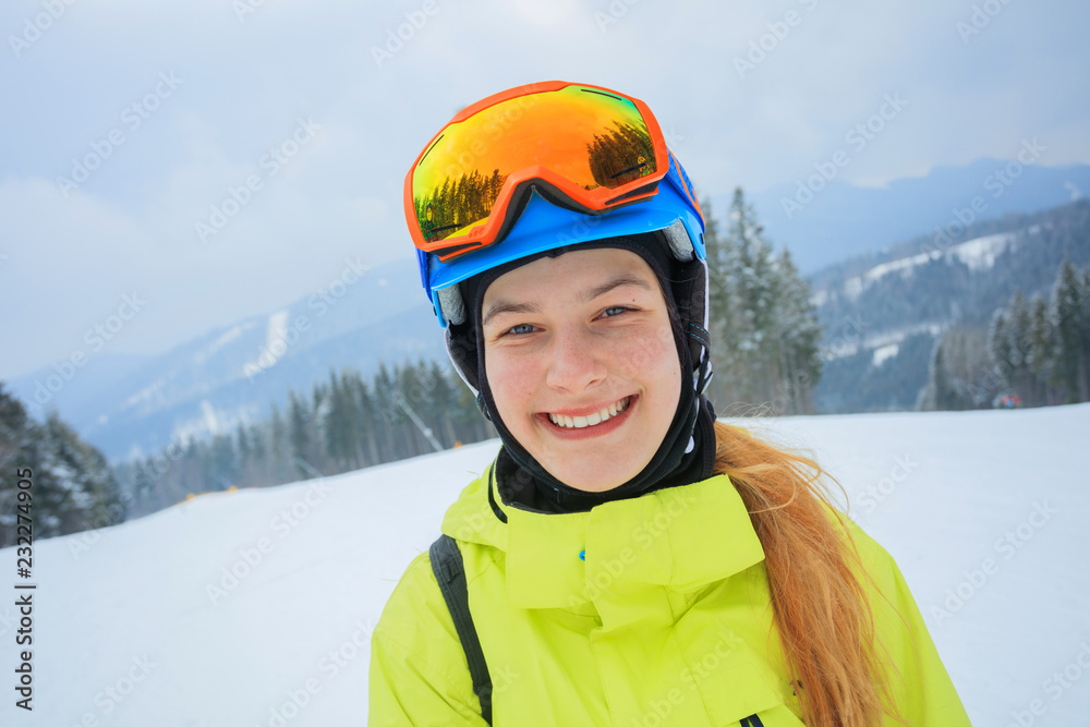Portrait of Girl snowboarder enjoys the winter ski resort.