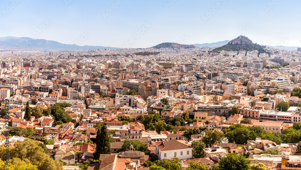 Athens city panorama with small greek buildings, churches and hills on horizon.