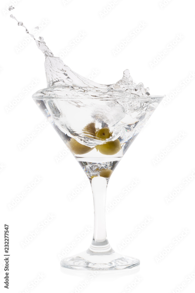 Splash of martini with olives in cocktail transparent glass on t Splash of martini with olives in cocktail transparent glass on t
