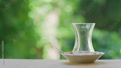 Slow motion shot of preparing Turkish tea in a garden with green background surrounded with trees. 