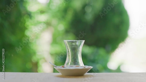 Slow motion shot of preparing Turkish tea in a garden with green background surrounded with trees. 
