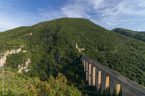 View of the Bridge of Tower (Ponte delle Torri) medieval aqueduct with the fortress (Fortilizio dei Mulini) Spoleto, Umbria, Italy photo