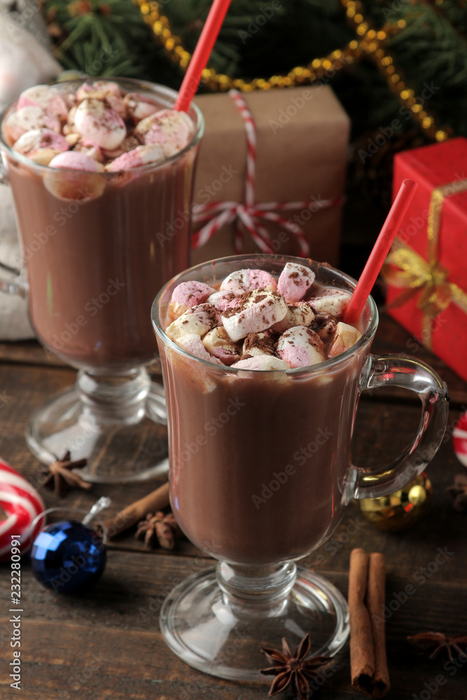 hot cocoa with marshmallows in a glass cup on a brown wooden background. Winter. new Year. Christmas. tree gifts hot cocoa with marshmallows in a glass cup on a brown wooden background. Winter. new Year. Christmas. tree gifts