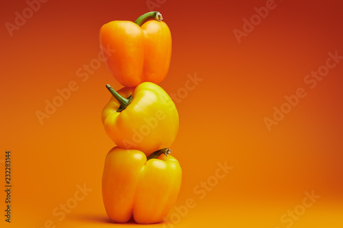 fresh ripe bell peppers on orange background