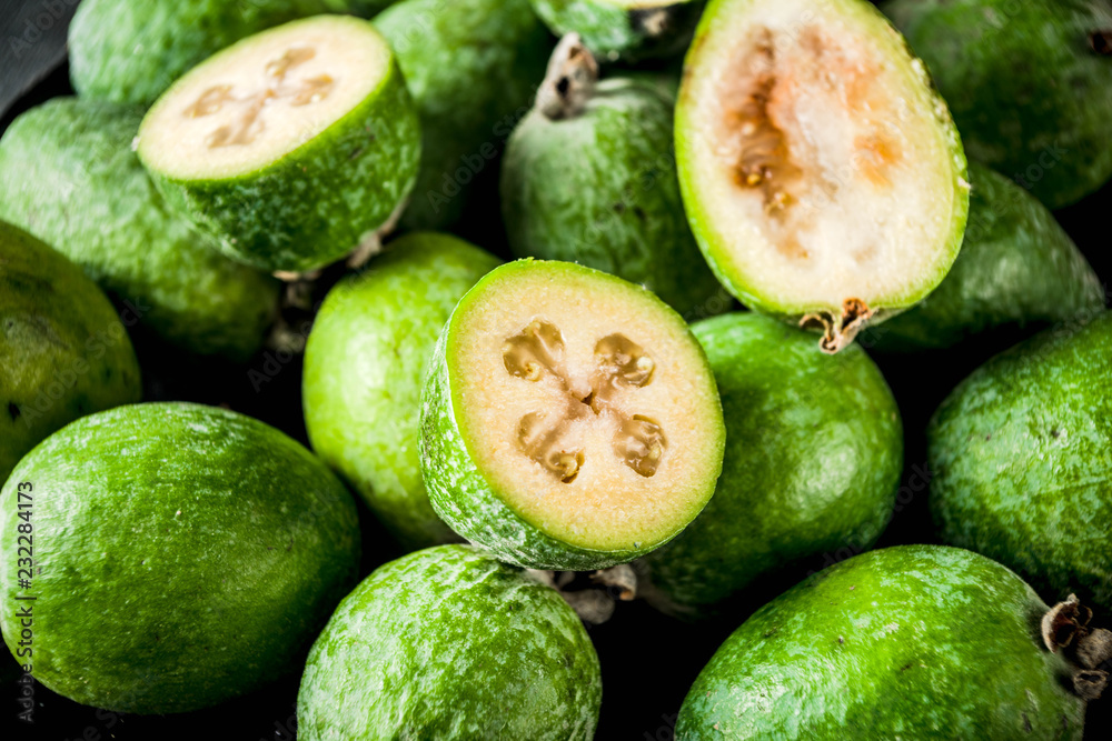 Tropical fruit, raw organic feijoa on a dark blue concrete background, copy space Tropical fruit, raw organic feijoa on a dark blue concrete background, copy space