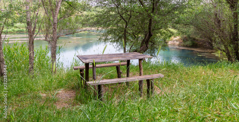 Wooden bench with a table by the lake Wooden bench with a table by the lake