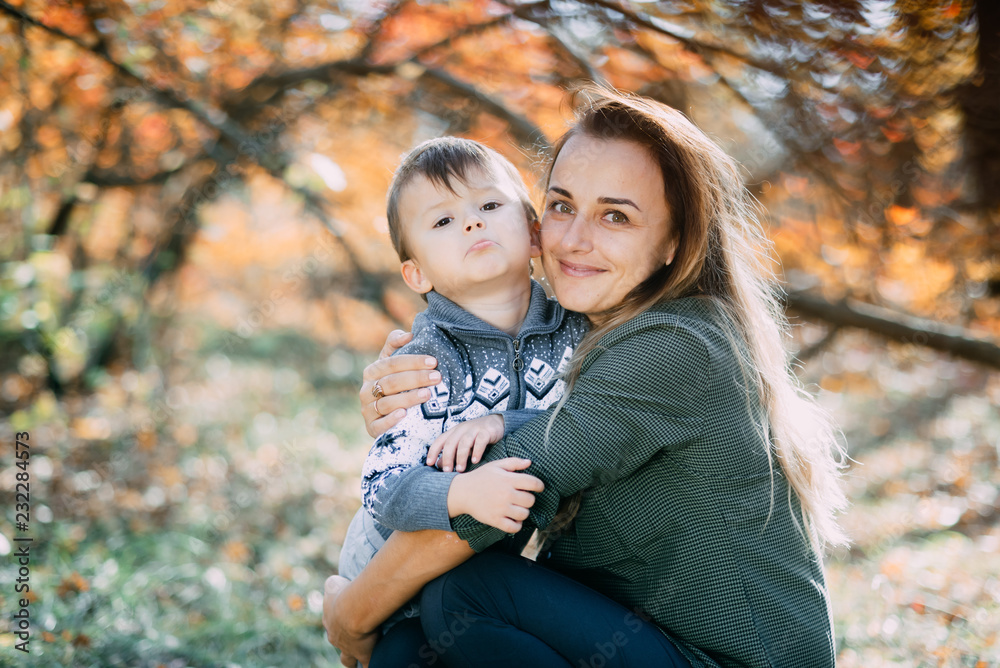 mother with son three years in autumn the forest, embrace and tenderness