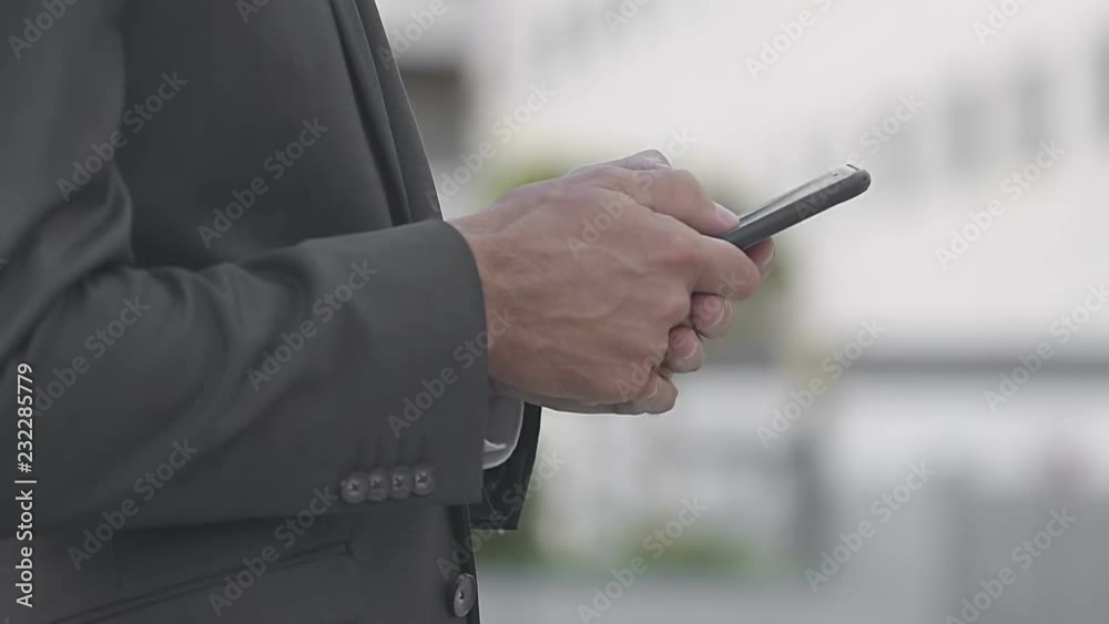 Cropped view of businessman using digital device. Side view of manager in suit chatting with someone. Gadget concept Cropped view of businessman using digital device. Side view of manager in suit chatting with someone. Gadget concept