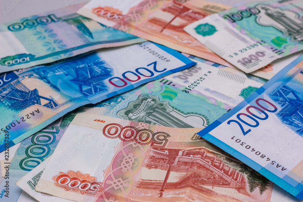 Obraz premium Russian banknotes scattered on the table, colorful colorful money close-up