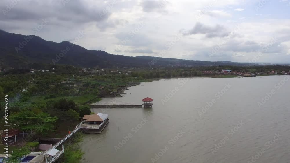 Messy coastal huts, houses and establishments built along lake shore. Drone Aerial