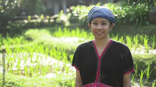 Asian ethnic woman with native dress smile at her organic rice field photo