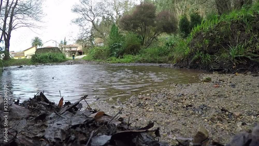 Sportsman with mountain bike crossing a stream in slow motion Sportsman with mountain bike crossing a stream in slow motion