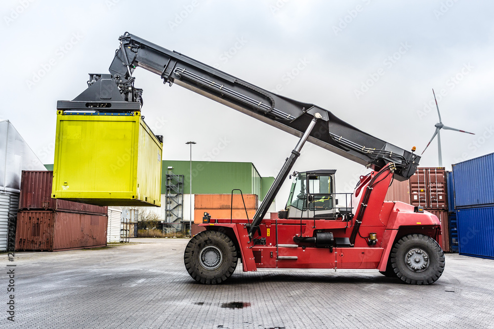Reach-Stacker carrying a yellow container Reach-Stacker carrying a yellow container