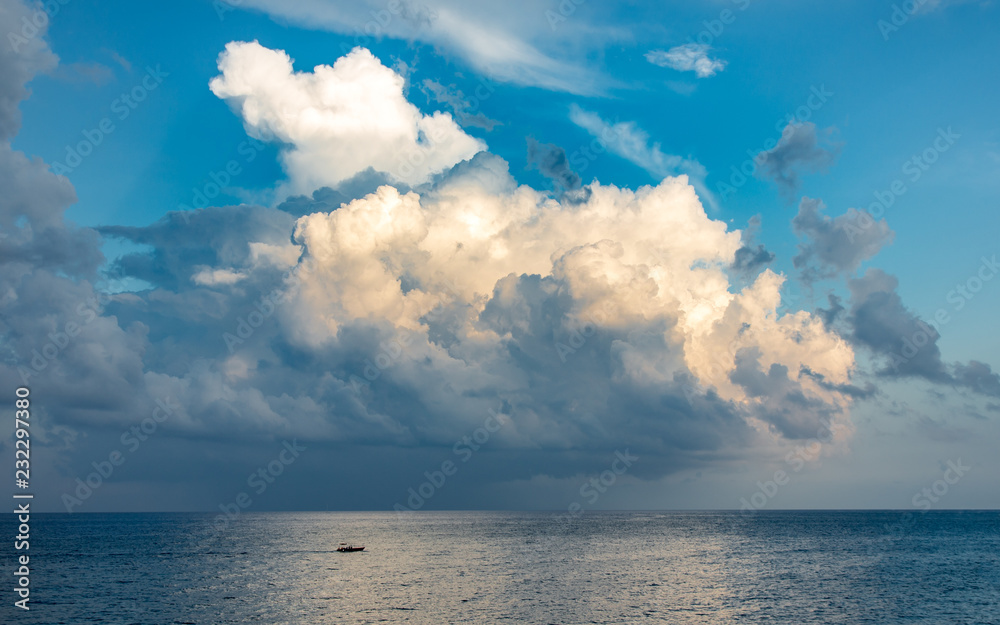 Wonderful seascape with small boat and heavy clouds