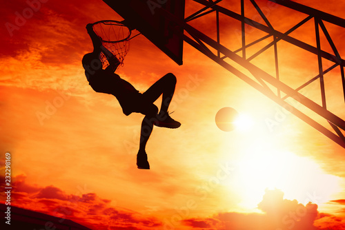 Basketball player performs a slam dunk