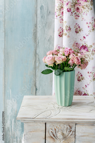 Bouquet of pink roses in ceramic vase.