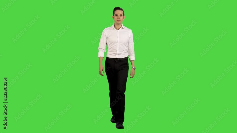 A young businessman walking relaxed towards camera in a full frontal shot, pointing up (use for pop ups), looking into the lens