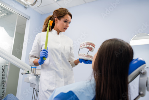Girl at the dentist learning how to brush her teeth