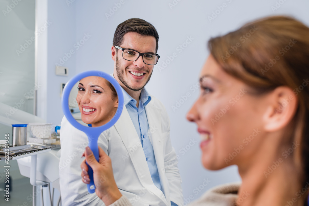Joyful cute young woman looking into the mirror Joyful cute young woman looking into the mirror