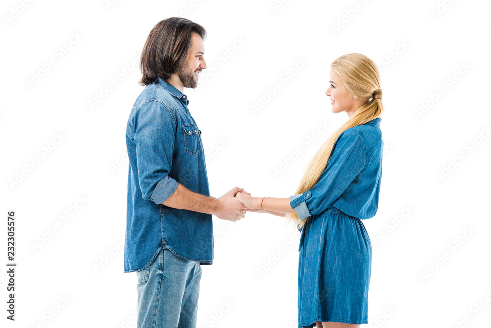 Amazing couple holding hands and amorously looking at each other isolated on white Amazing couple holding hands and amorously looking at each other isolated on white
