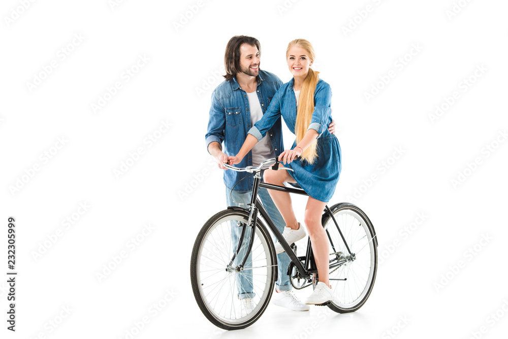 Blonde girl riding bicycle and man helping her isolated on white