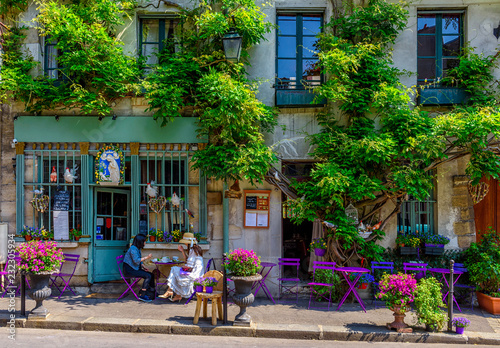 Cozy street with flowers and tables of cafe  in Paris, France © Ekaterina Belova