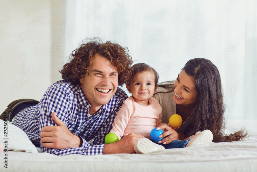 Happy family playing with the baby in the room. Young mother and Happy family playing with the baby in the room. Young mother and