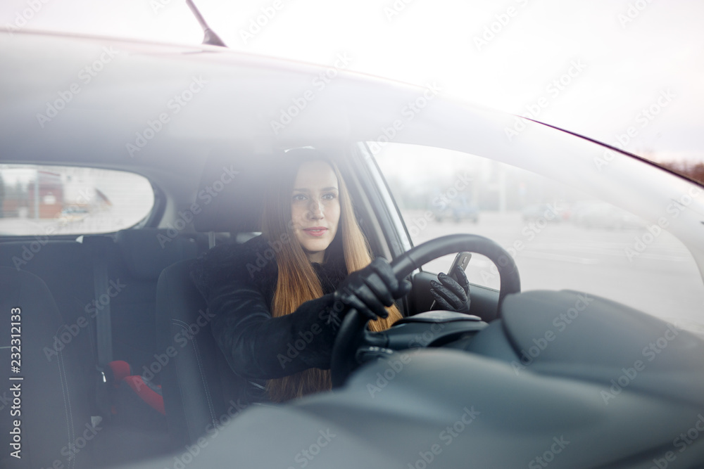 Fototapeta premium Young lady driving a car in winter