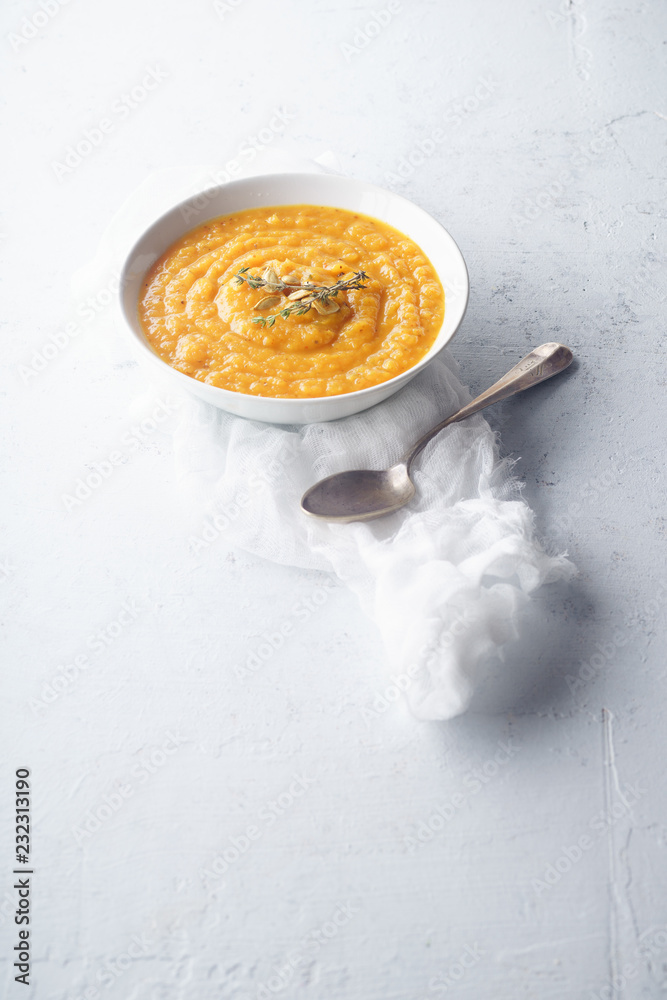 Pureed pumpkin soup with seeds and thyme. Warm food concept, dieting. Concrete background, overhead view. Copy space Pureed pumpkin soup with seeds and thyme. Warm food concept, dieting. Concrete background, overhead view. Copy space