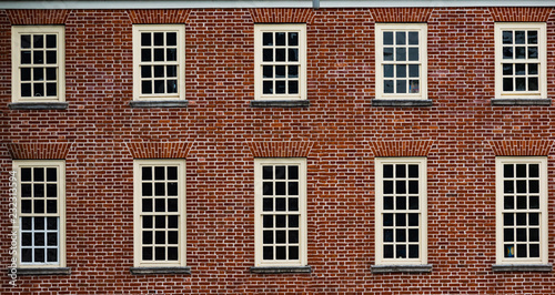 Red brick vintage style building facade with multiple windows