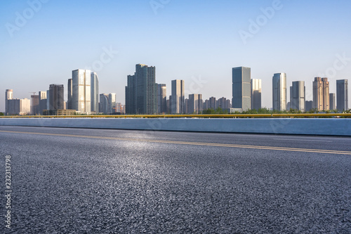 empty asphalt road with city skyline © THINK b