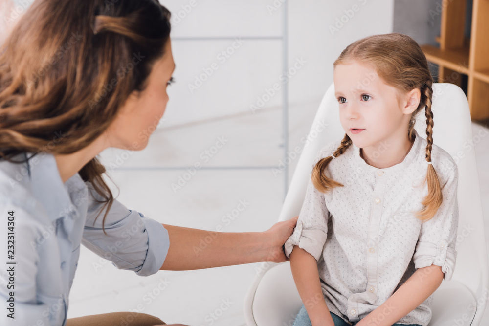 close-up shot of adult psychologist talking with little patient in office close-up shot of adult psychologist talking with little patient in office