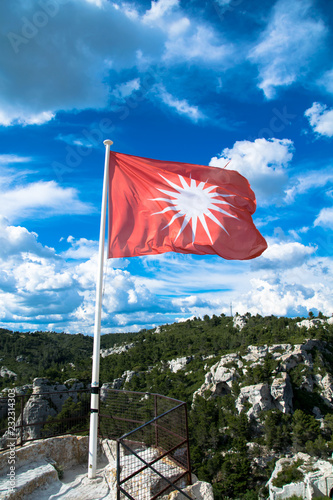 The red flag of the medieval village of Les-Baux-de-Provence in the Alpilles regional park, France