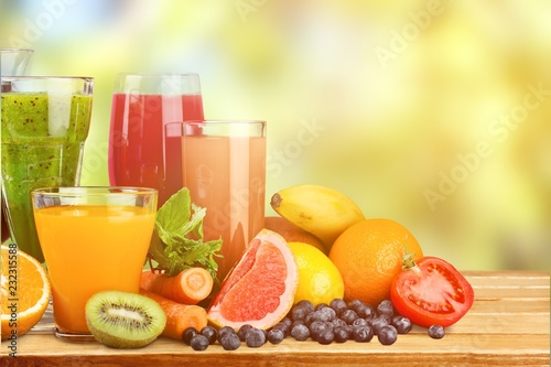 Tasty fruits and juice with vitamins on background