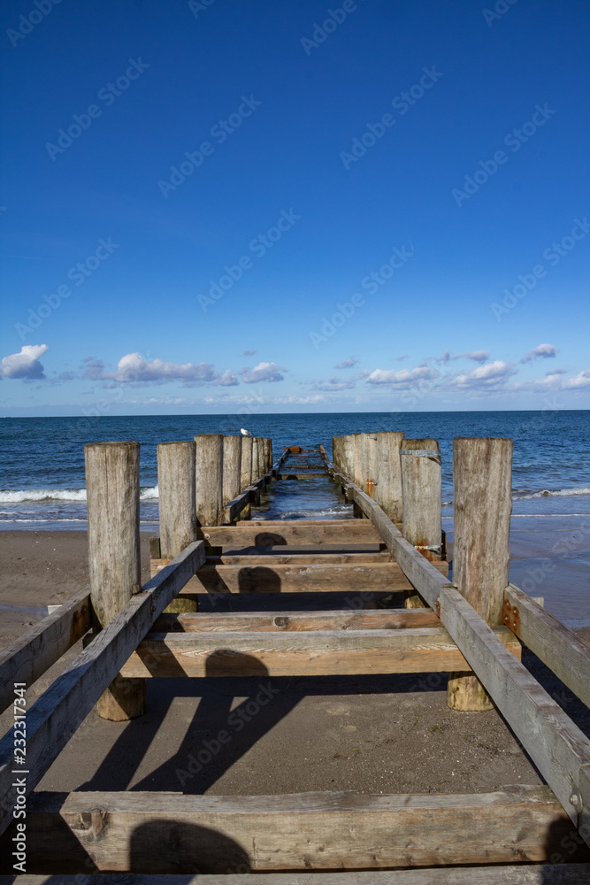 Ein alter Bootssteg führt vom Strand in die Ostsee