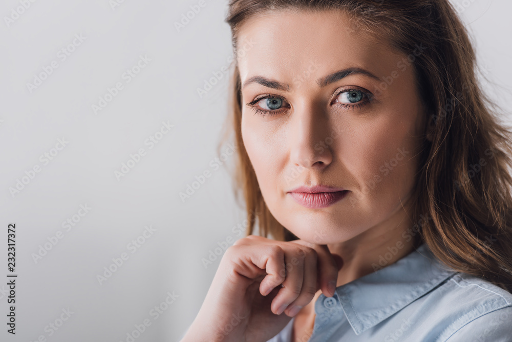 Close-up portrait of thoughtful adult woman looking at camera