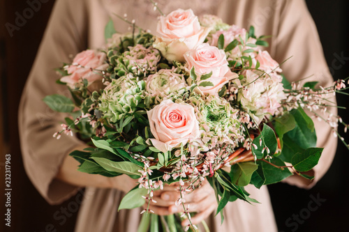 Woman holding bouquet of fresh soft pink roses