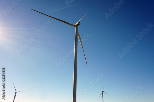 Eco power, wind turbines with blue sky. wind turbine for alternative electricity.renewable electric farm with sustainable eco-friendly technology using wind energy rotation for wind turbines renewable © MishaelPervak