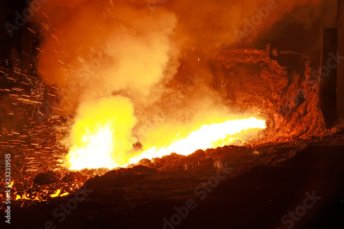 hot molten iron flowing from blast furnace photo