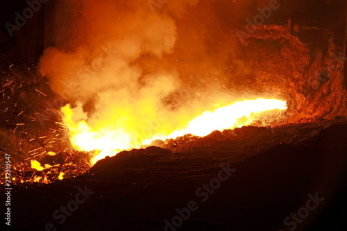 hot molten iron flowing from blast furnace photo