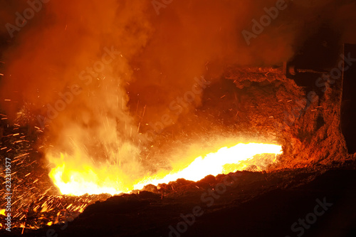 hot molten iron flowing from blast furnace photo