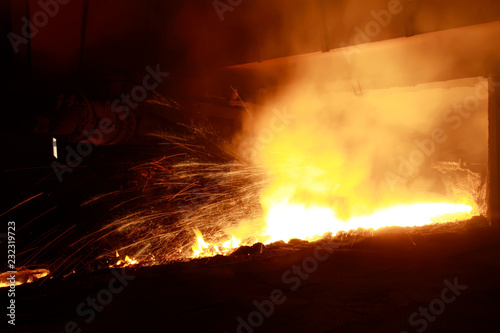 hot molten iron flowing from blast furnace photo